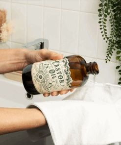 castor oil with hands and pack