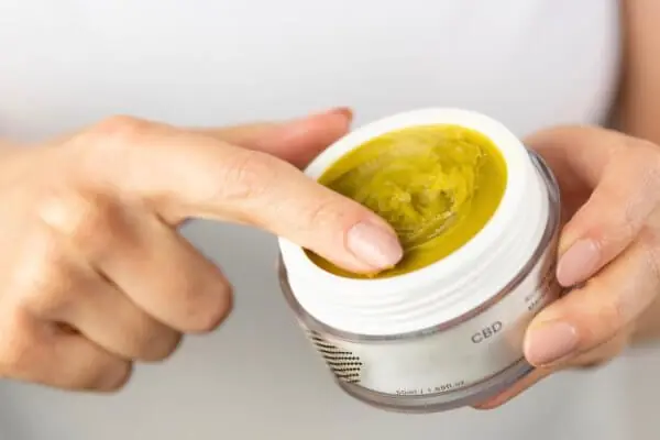 woman holding CBD salve in jar